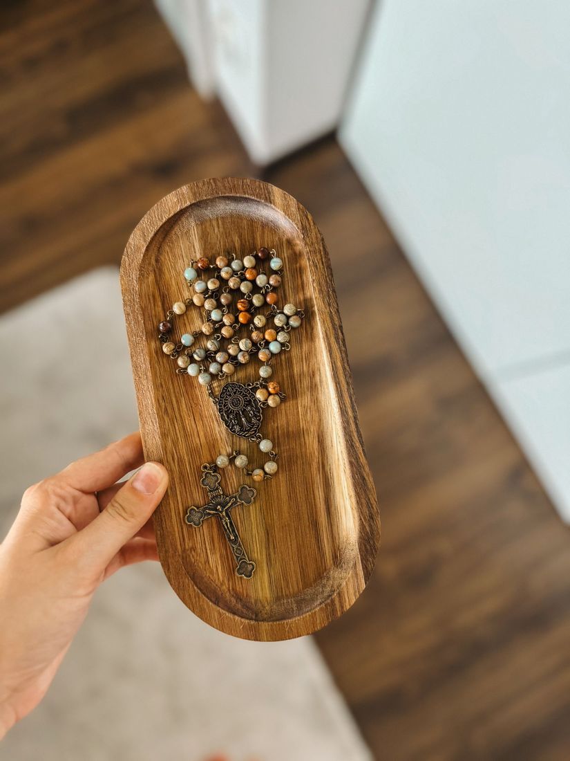 różaniec z kamieni jaspisu na drewnianej podkładce